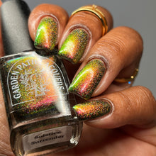 Load image into Gallery viewer, A complex red-bronze to gold to green-blue shifting multichrome nail polish filled with gold holographic microglitter